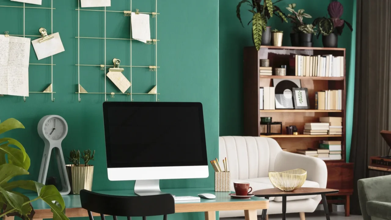 plant next to a wooden chair with desktop computer in