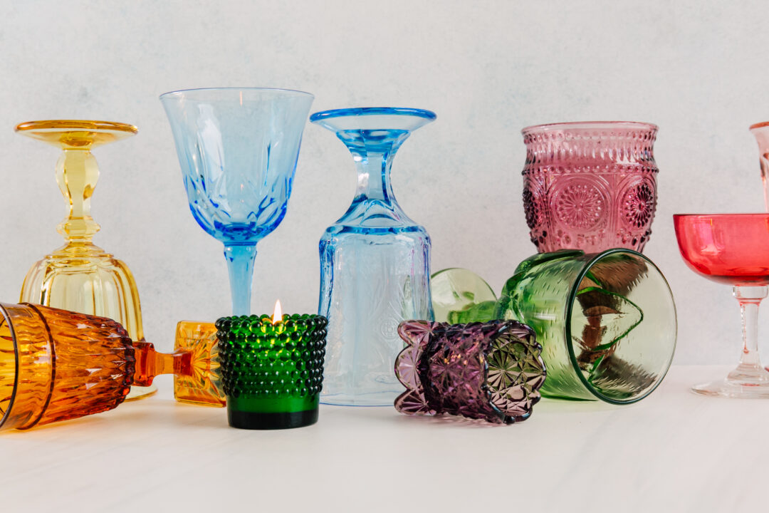 A set of different vintage glassware on a white surface.