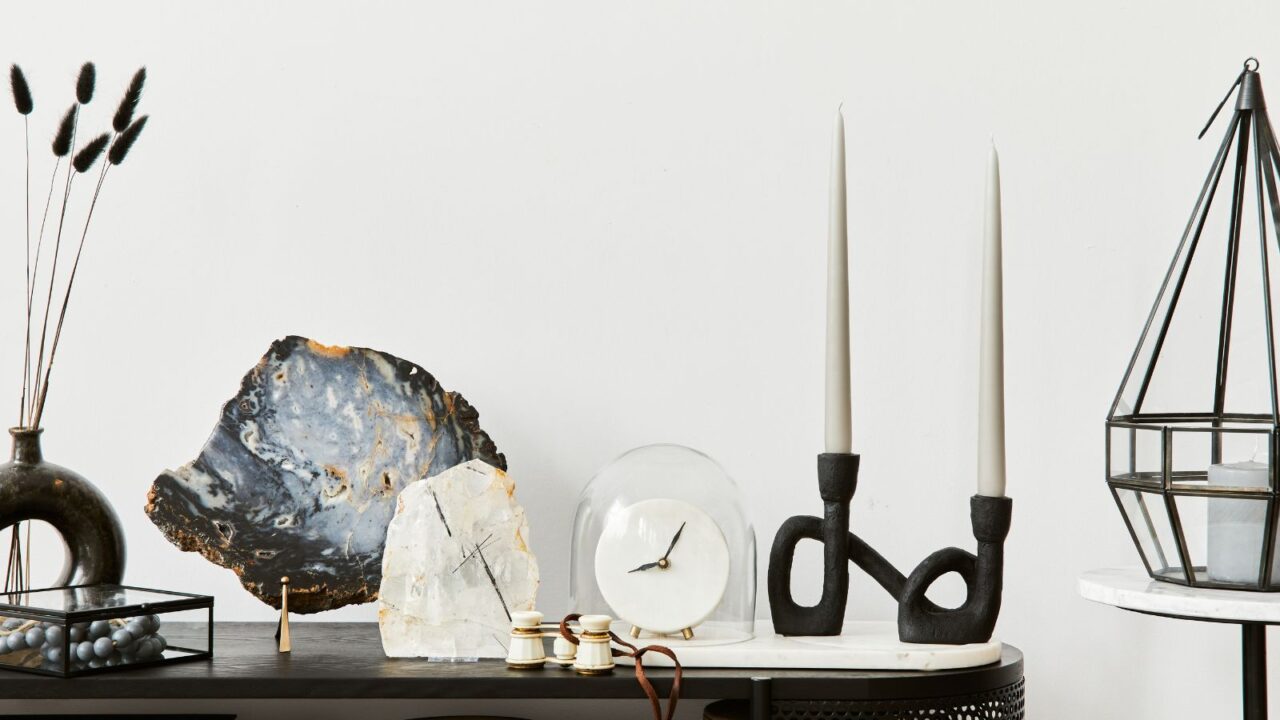 Elegant living room interior composition with console, candlestick, gemstone and sculptural decor.