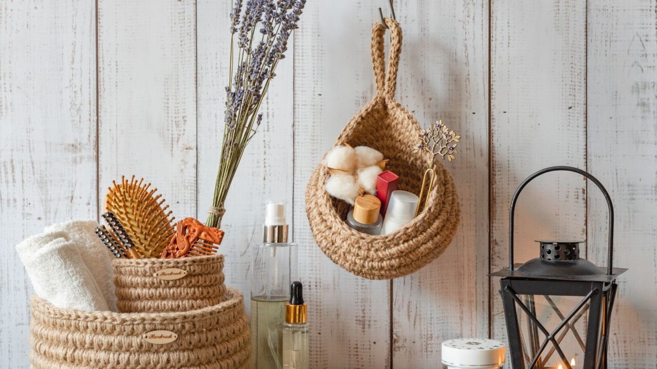 Cozy interior in the bathroom with white towels, lavender and hand-knitted jute boxes for accessories and cosmetics, eco-friendly and natural materials, Scandinavian style.