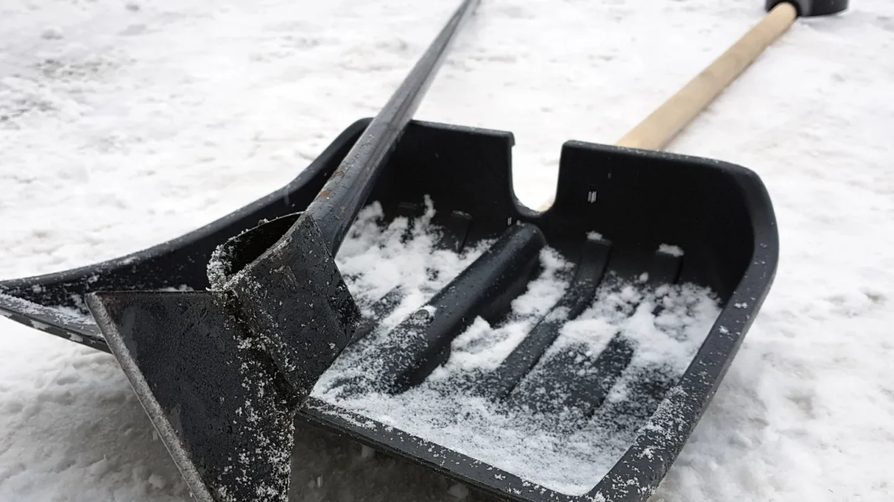 snow shovel and ice ax lie on the snow in