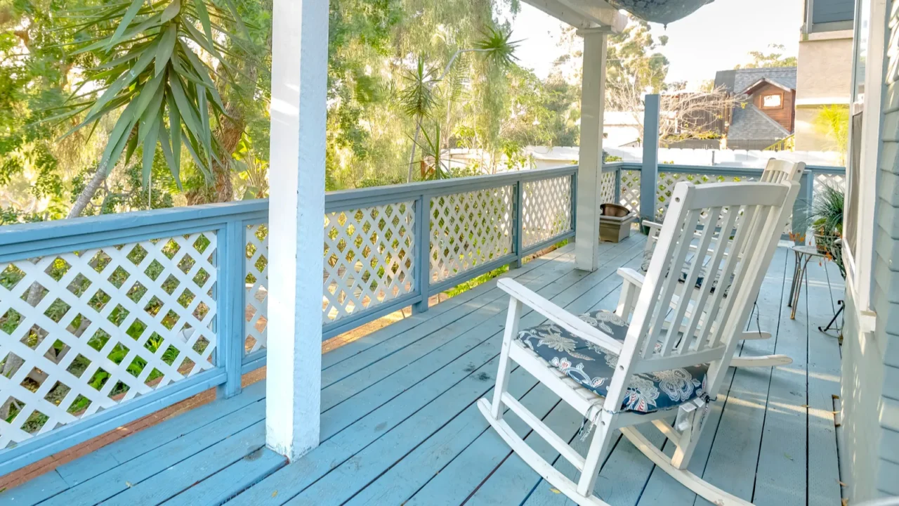 A white rocking chair on a southern porch.