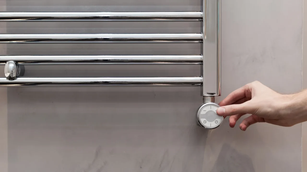 the man hand regulates the temperature in the heated towel