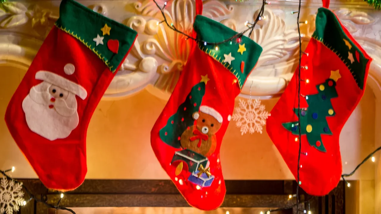 three christmas stockings hanging on decorated fireplace