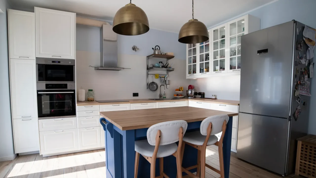 white bright scandi kitchen with blue island and double brass