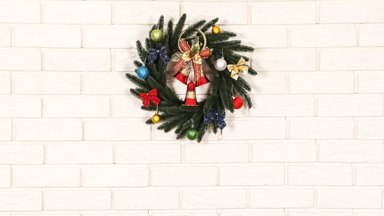 white decorated fireplace with wreath on brick wall background