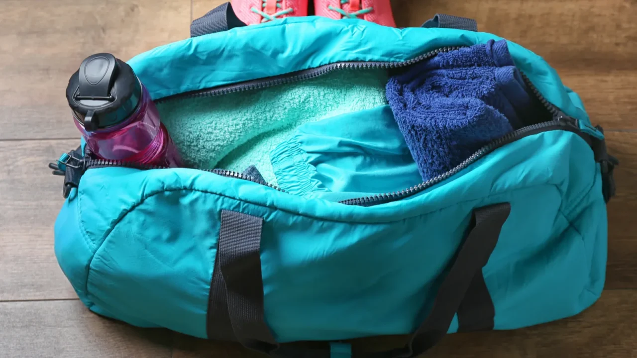 woman standing next to bag with fitness equipment