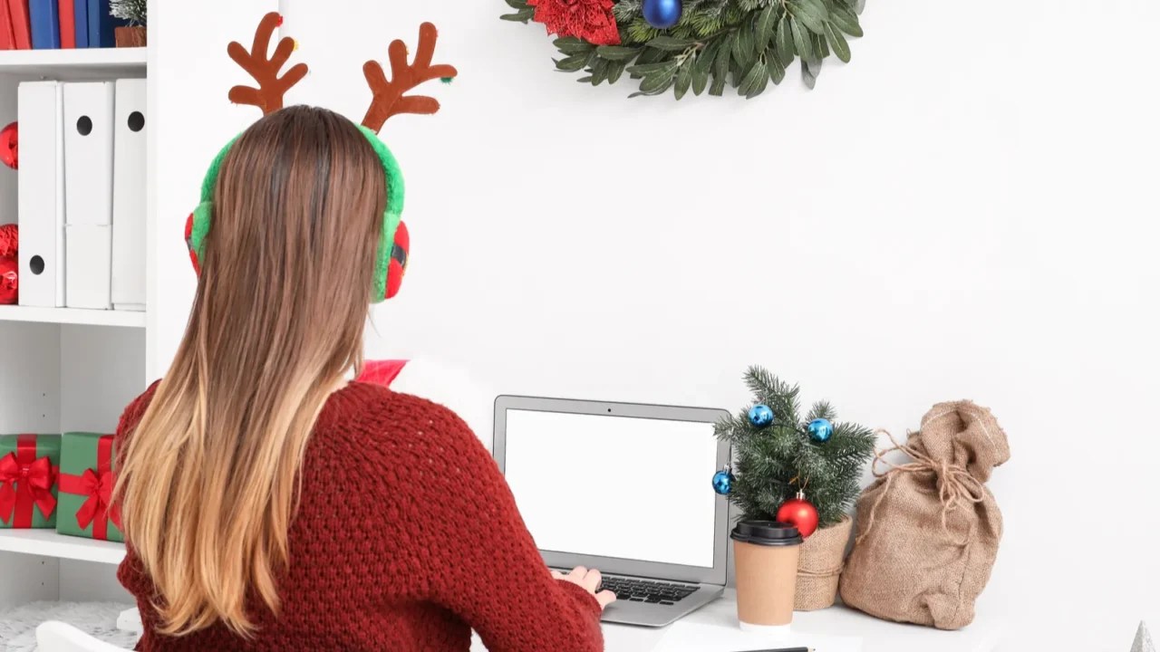 Woman working at a decorated holiday desk.