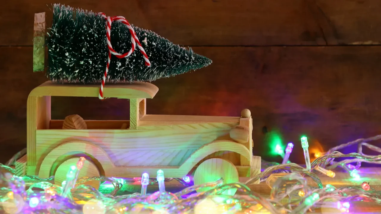 wooden car carrying a christmas tree on rustic table