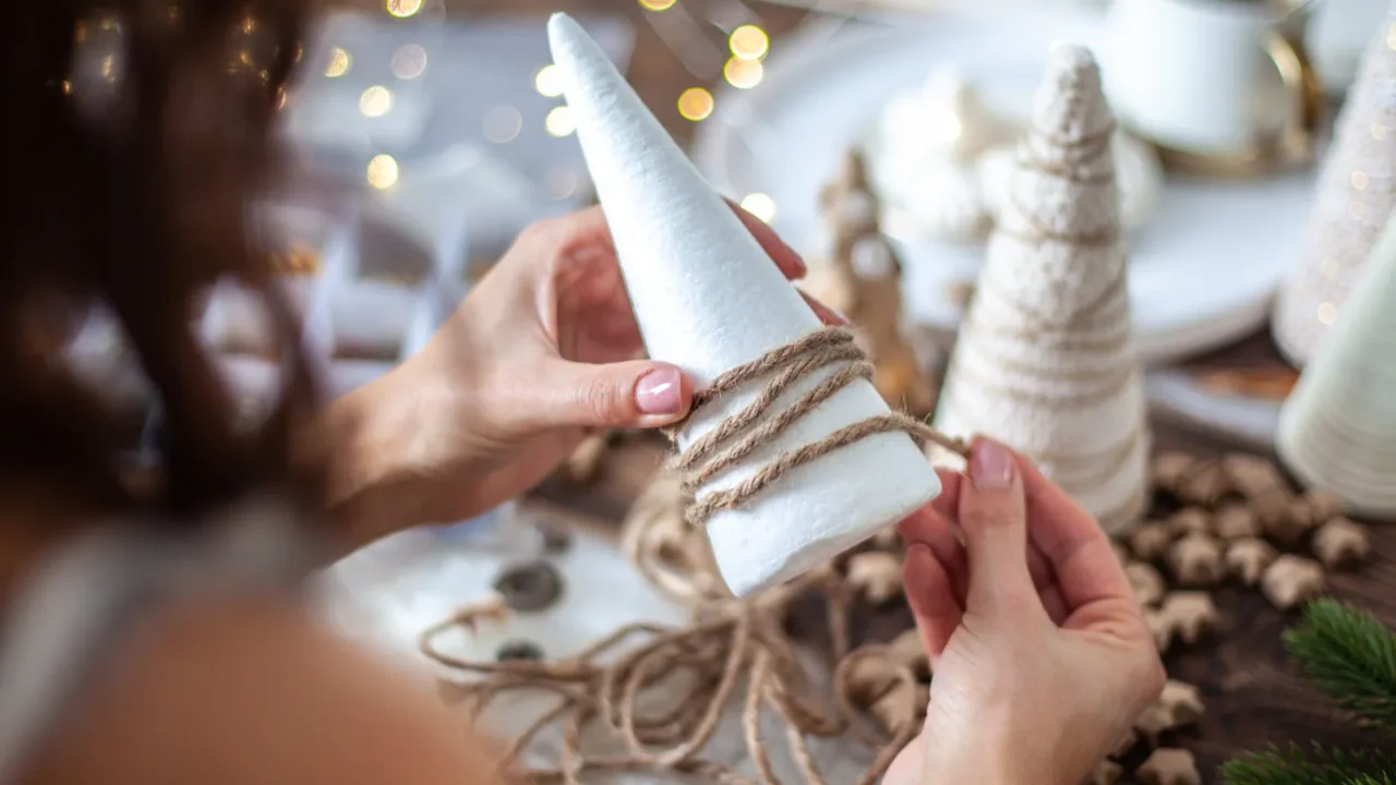 young beautiful woman wrapping a foam cone with string yarn