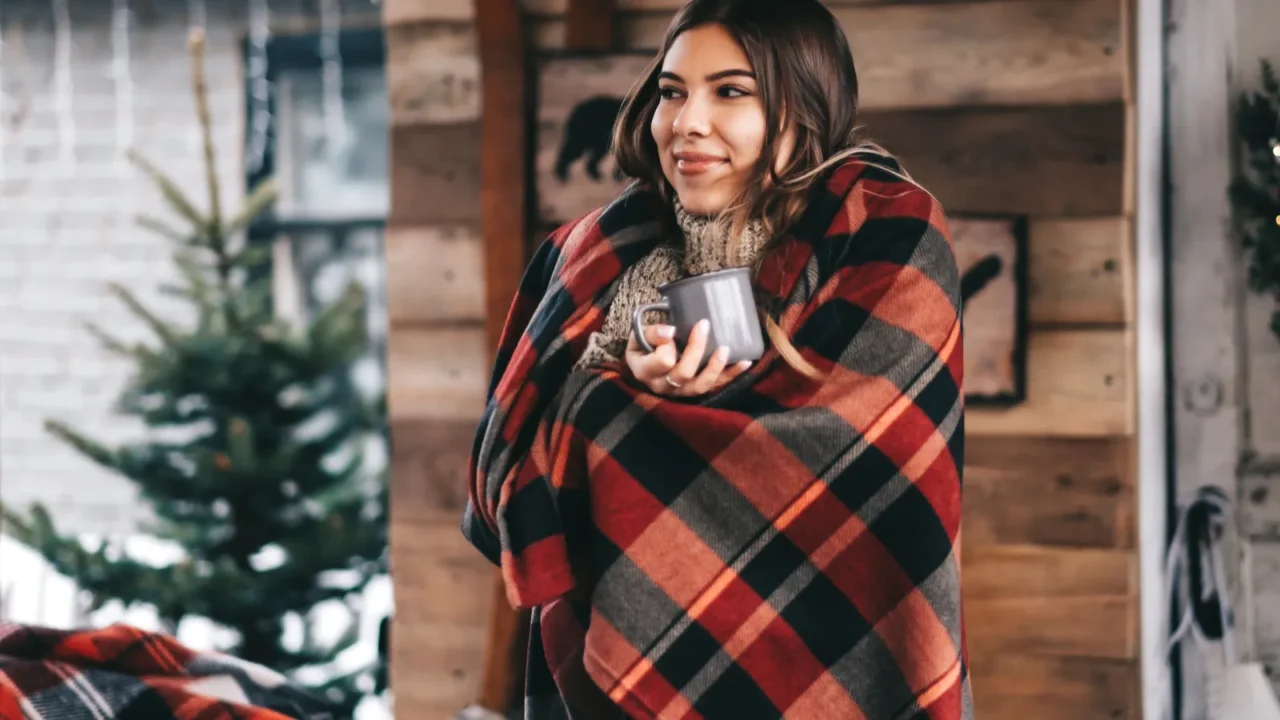 young caucasian happy woman in a plaid is drinking a