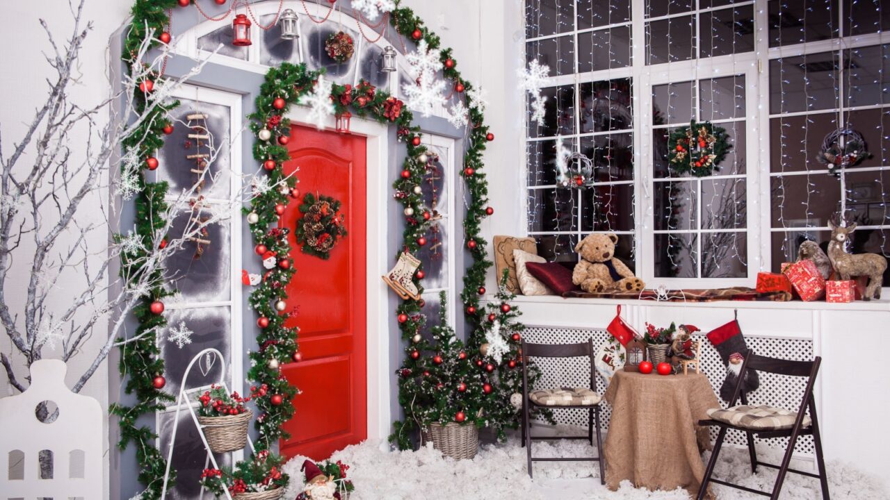 Red door with Christmas wreath and tree branches