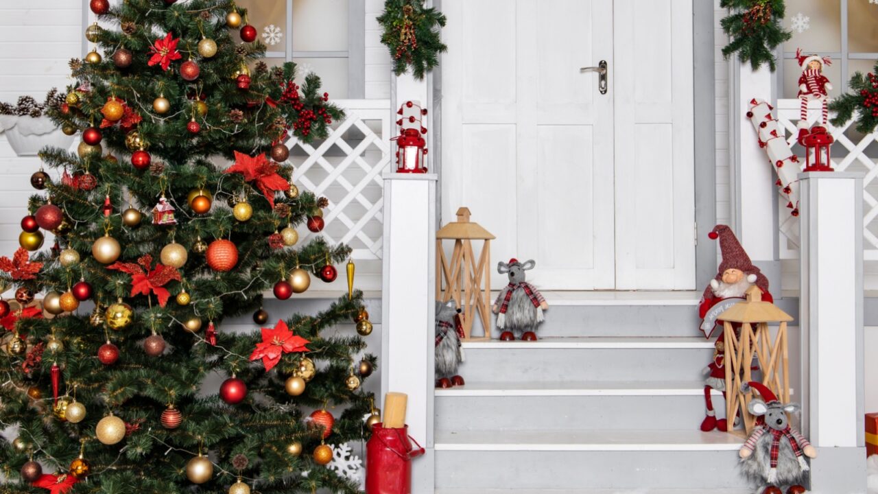 Christmas home facade festive decoration view colorful toys and objects near building porch in white red and green colorful