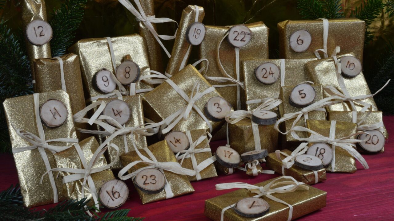 Advent calendar with twenty four golden presents on red wood