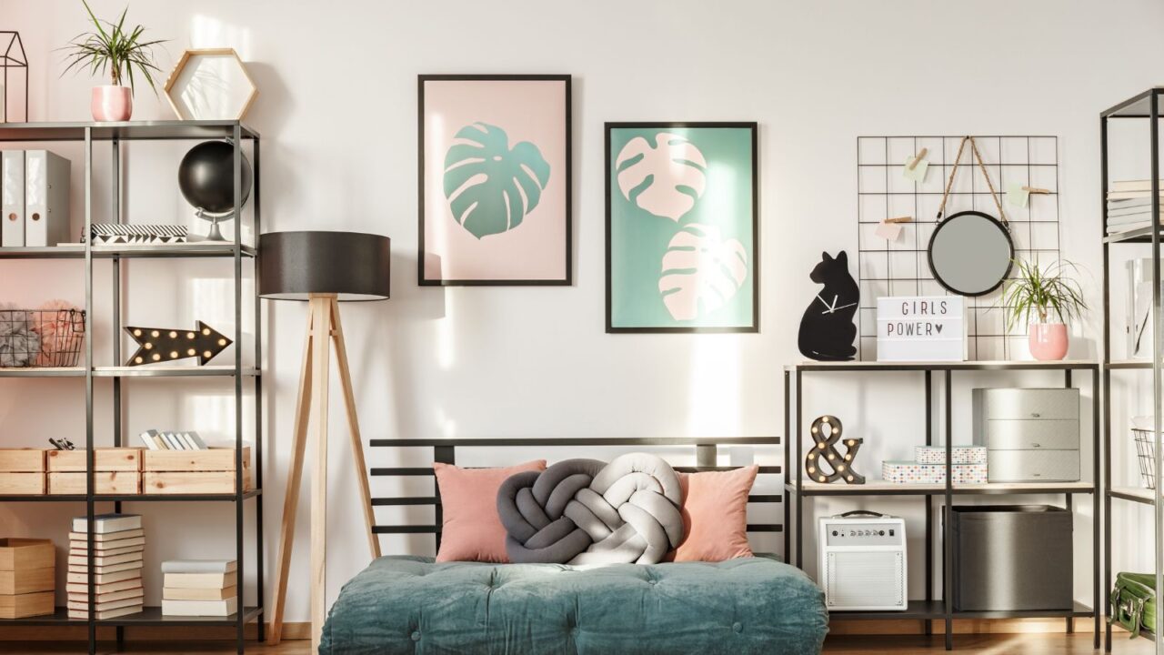 A living room interior with a sofa, shelf with decor accents, mesh grid, lamp, and frames on the wall