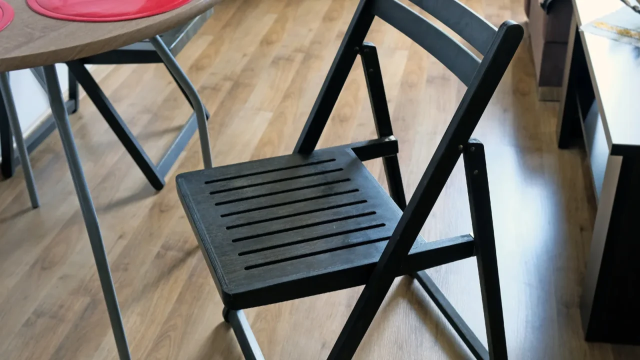 a black wooden chair in the middle of the kitchen