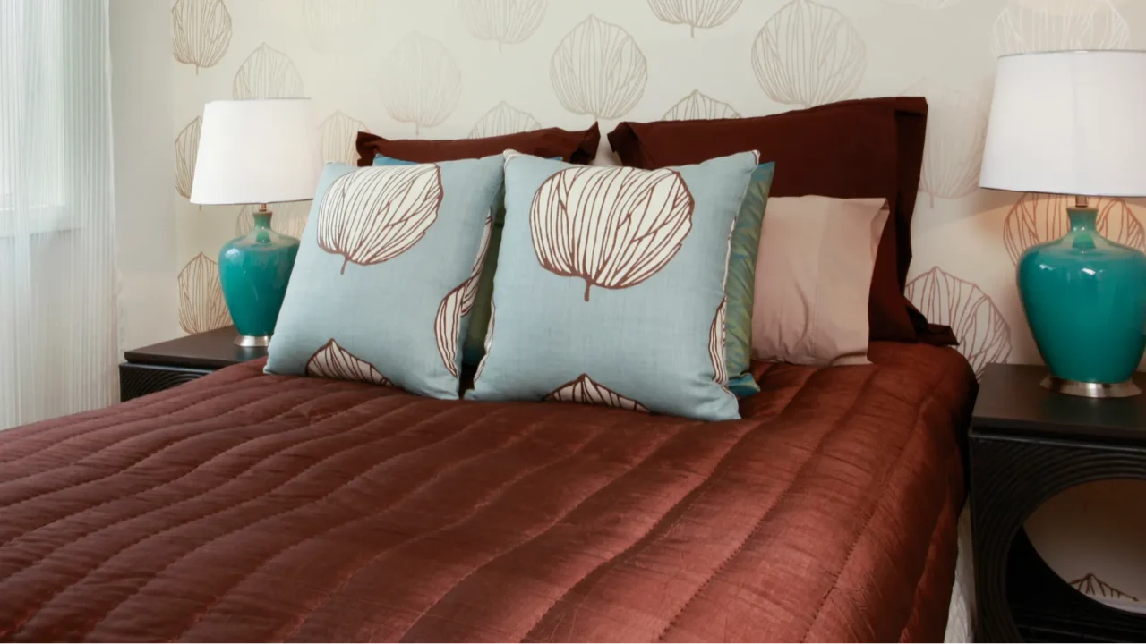 a brown bed linen and aqua pillows