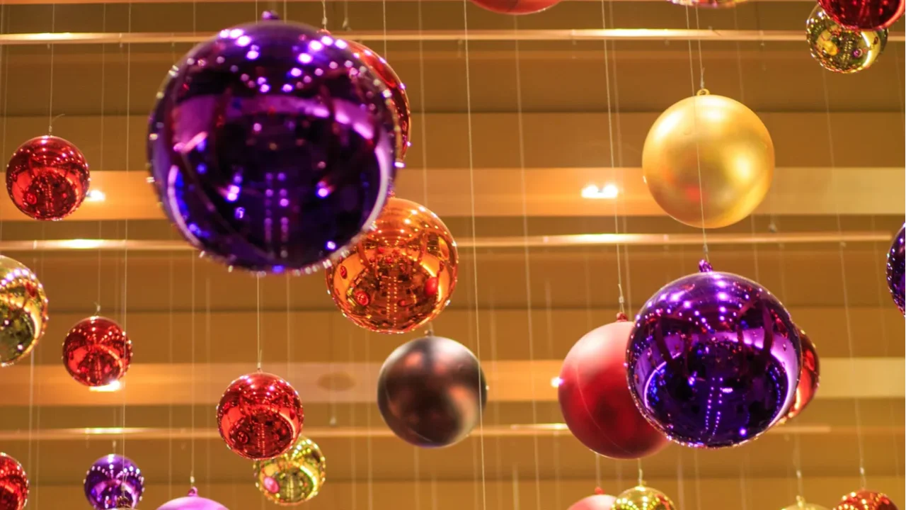 a bunch of colorful christmas ornaments hanging from the ceiling