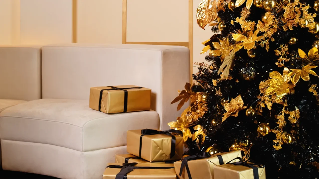 a christmas tree with gold and black decorations and gifts