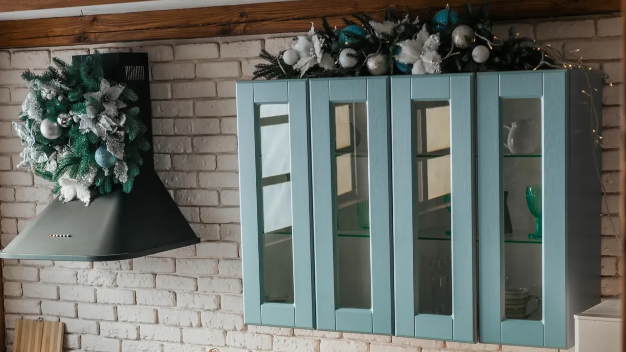 a modern kitchen features charming blue cabinetry with glass doors