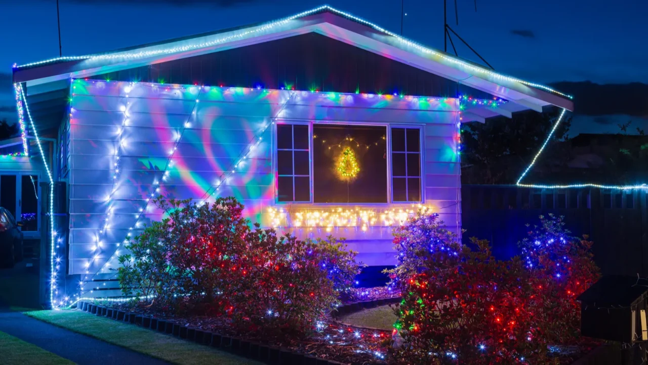 a suburban house at night decorated for christmas with colorful