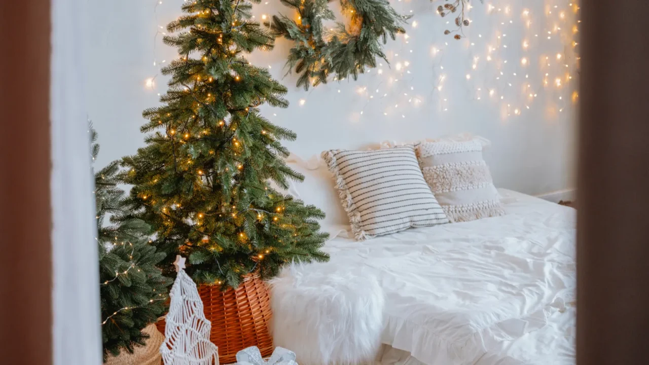 a warm and inviting bedroom features small christmas trees twinkling