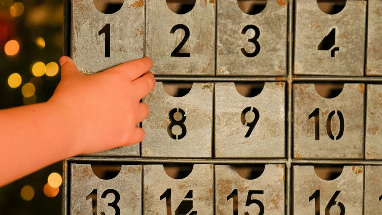 advent calendar in vintage style and childs hand near christmas