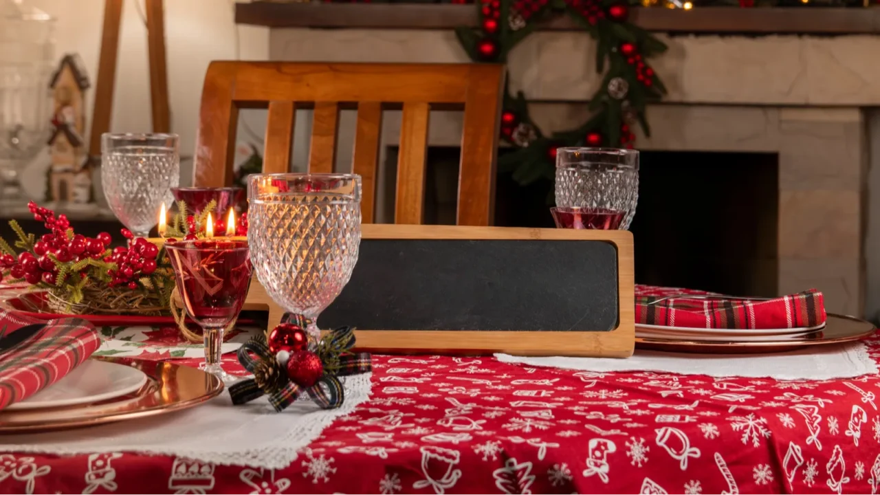 charming holiday dining setup featuring a red tablecloth elegant glassware