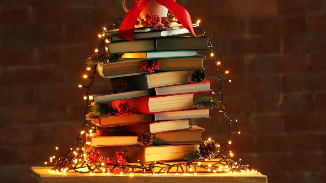 christmas tree made of books on table on brick wall