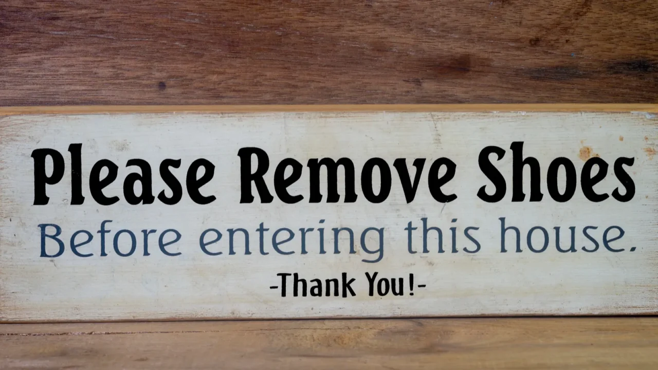 close up wooden sign please remove shoes sign with the