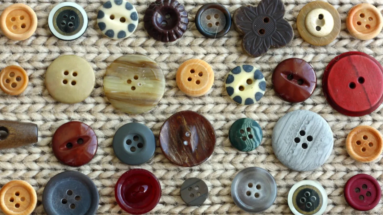 collection of vintage buttons scattered on fabric background