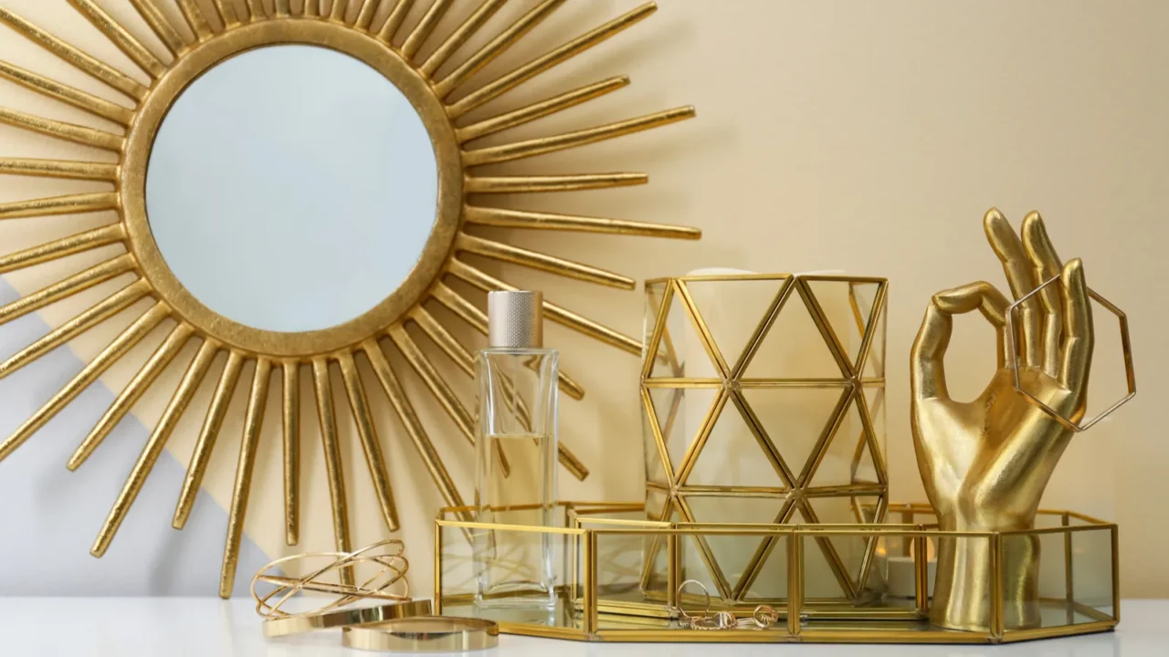 Composition with golden accessories and jewelry on dressing table near