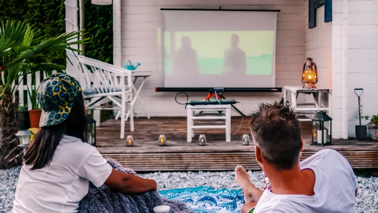 couple looking at movies in the garden at night people