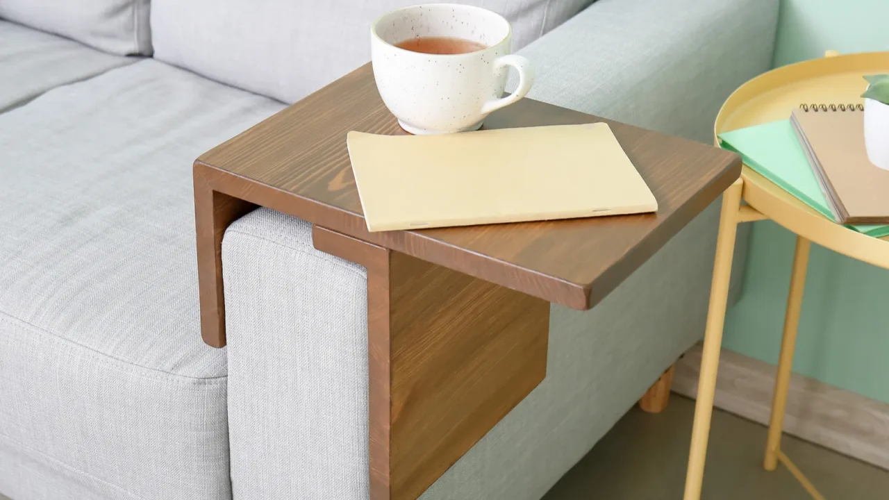 cup of tea with notebook on armrest table in room