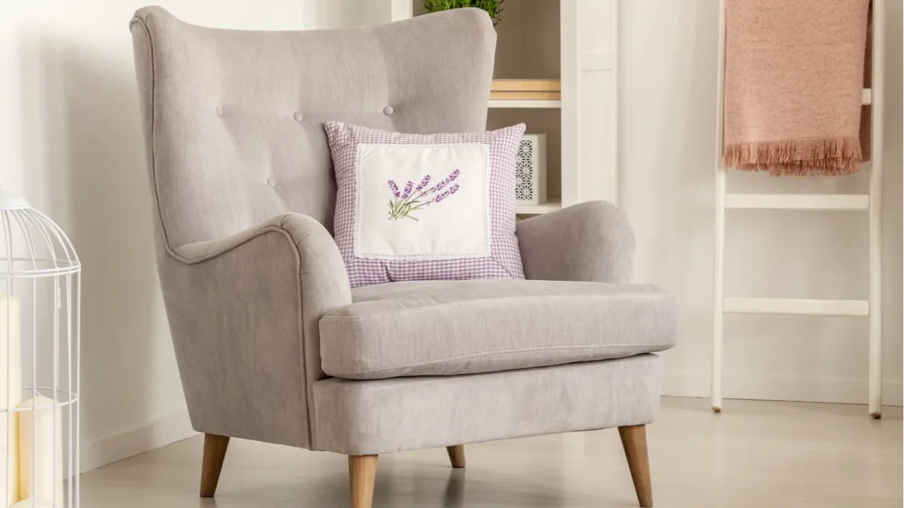 cushion on grey armchair in bright living room interior with