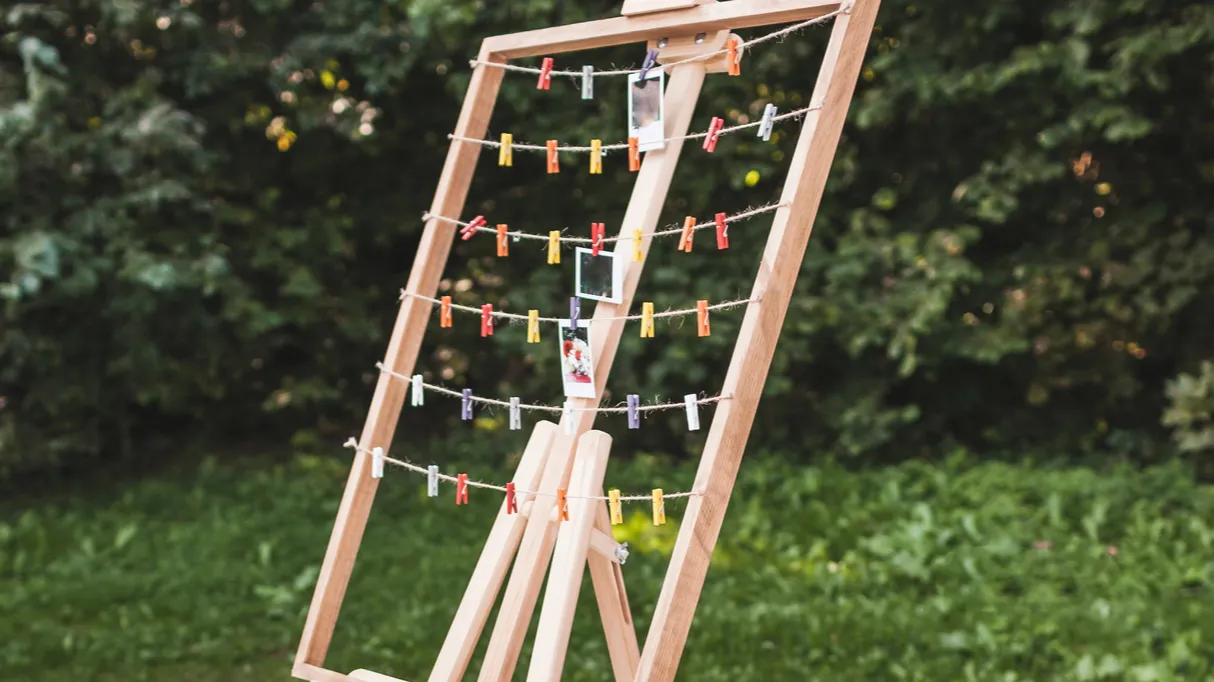 decorated wooden table and hanger for polaroid photos for guests