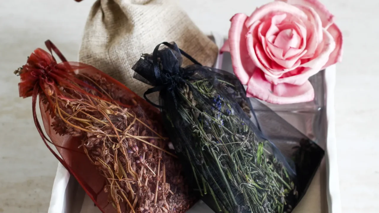 dried scented herbs in red decorative bag and rose in