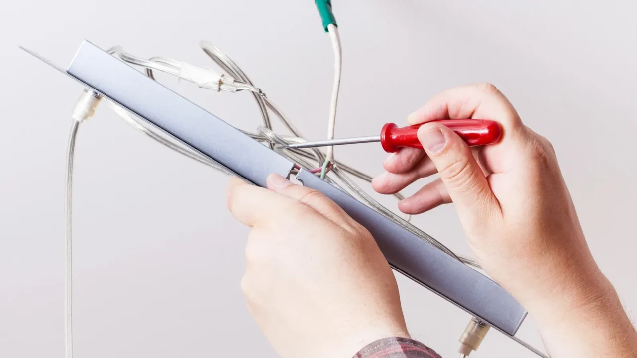 electrician repairs wiring in ceiling lamp