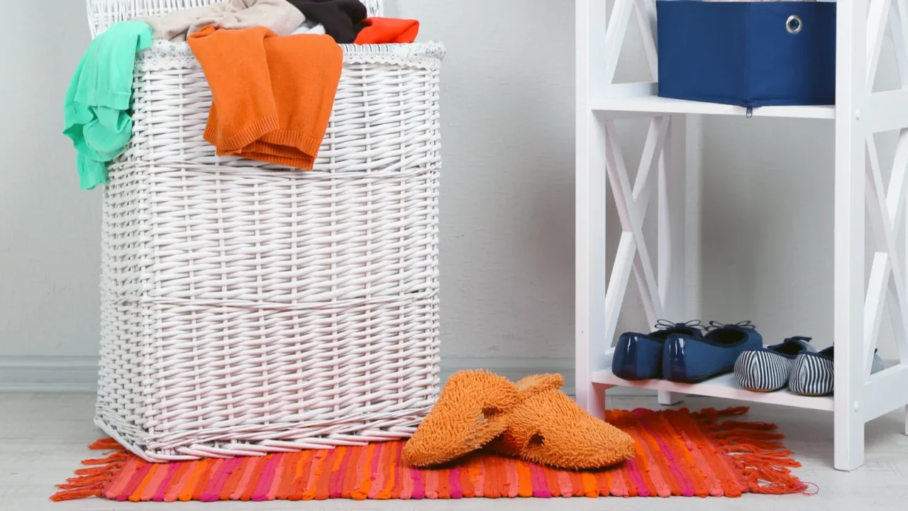 full laundry basket on wooden floor on home interior background