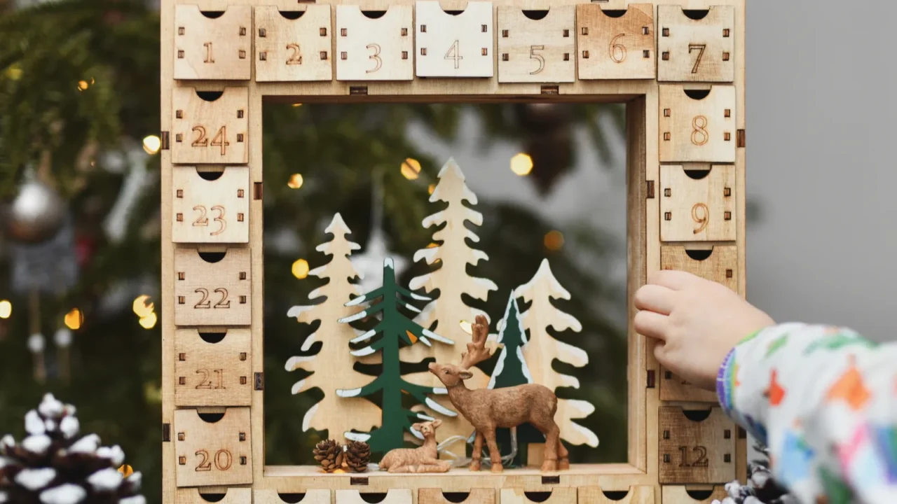 girl opens wooden advent calendar