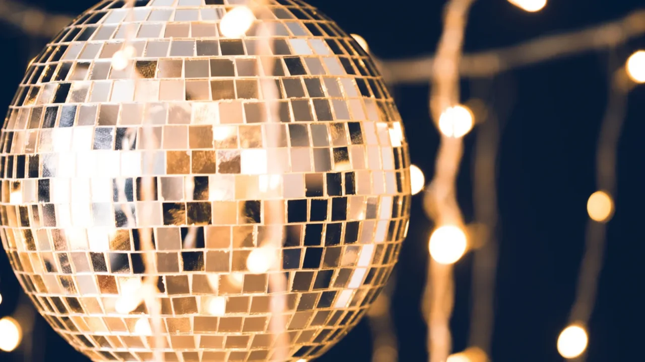 glossy disco ball with garland on black background