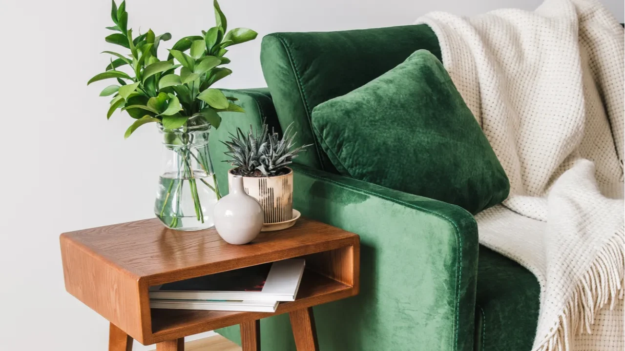 green sofa with pillow and blanket near wooden coffee table