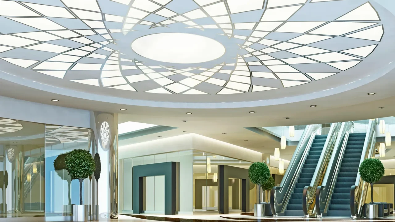 Hall in a shopping center in a modern style. Geometric ceiling and elevators.