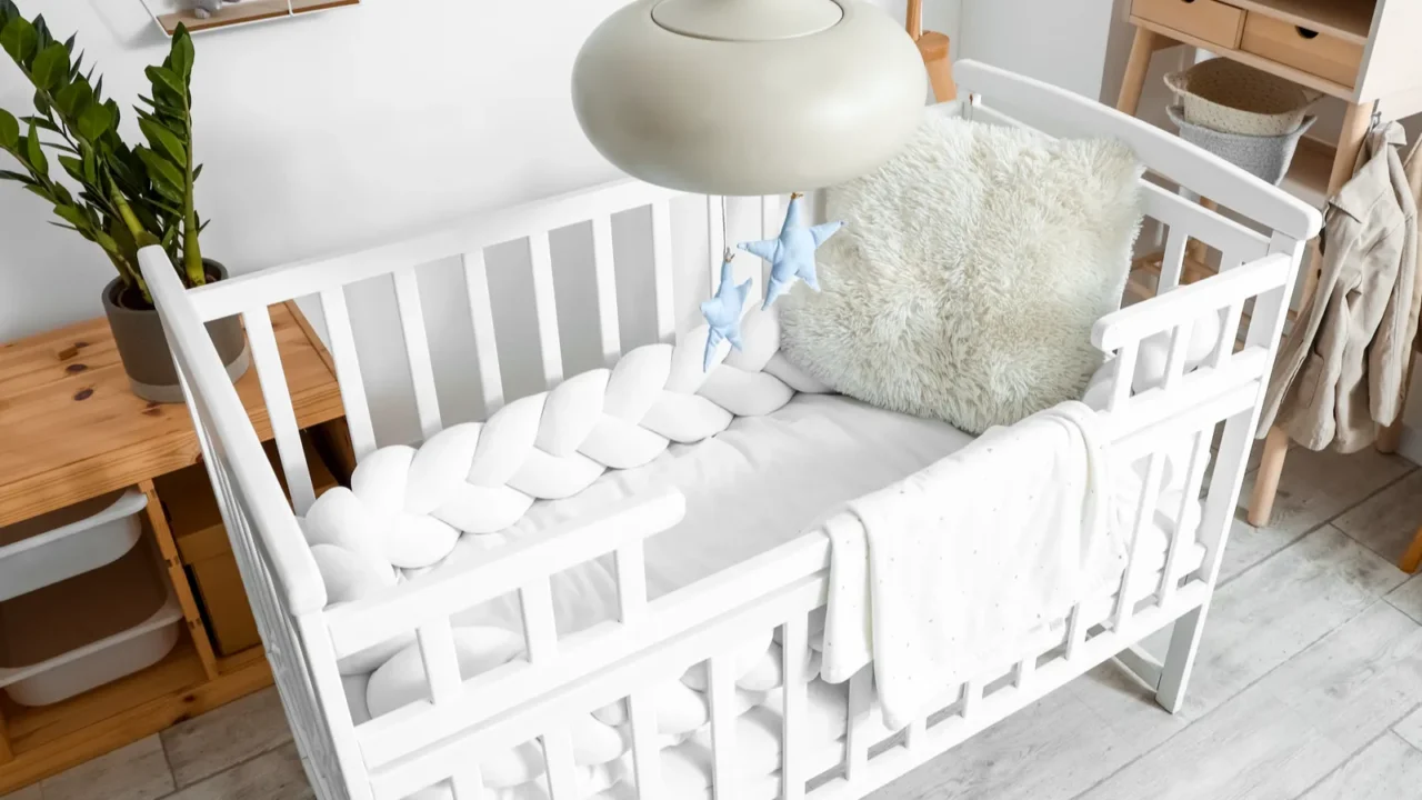 interior of light childrens bedroom with baby crib and table