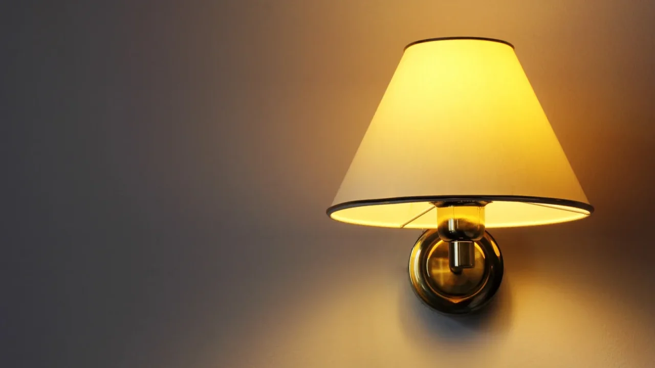 A wall sconce with yellow shade.