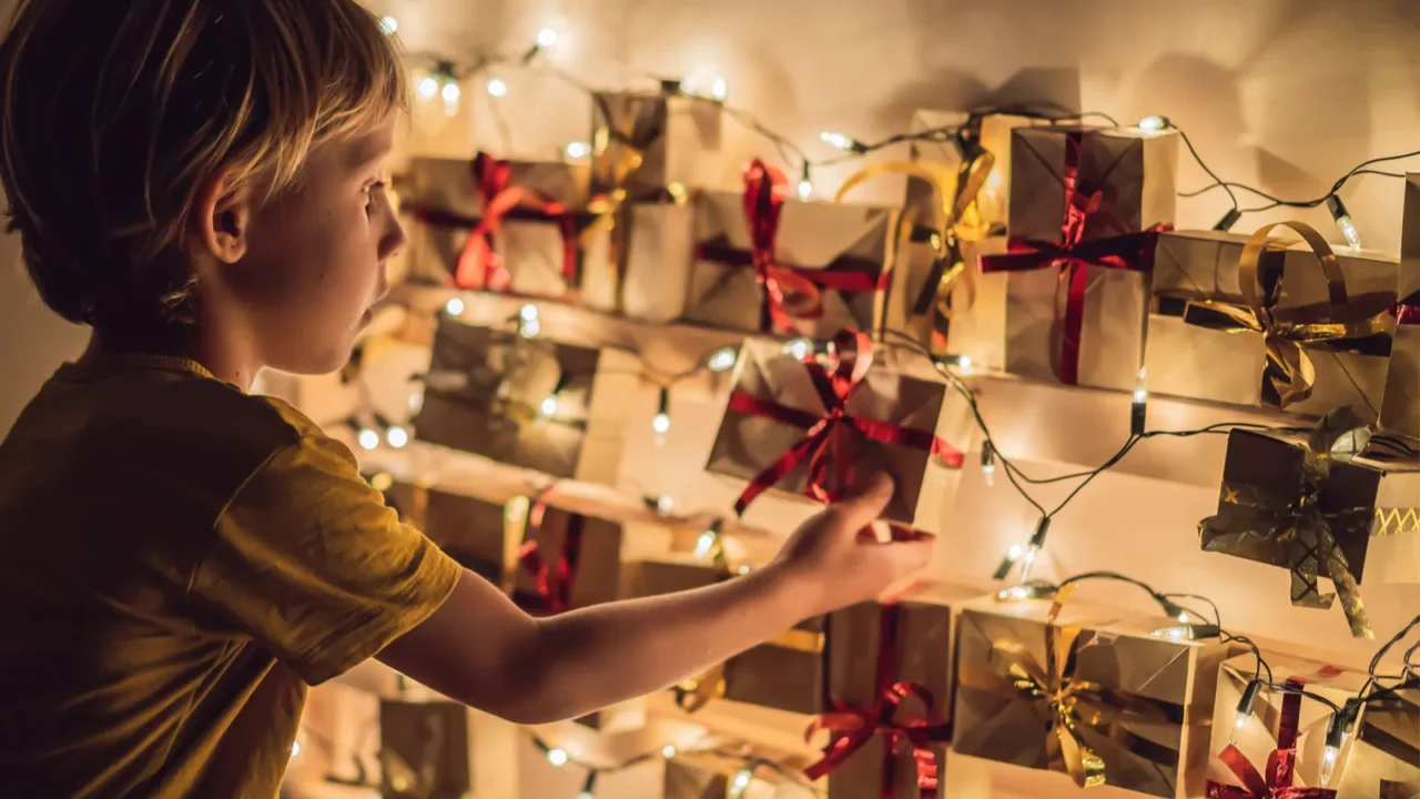 little boy opening gift from christmas advent calendar