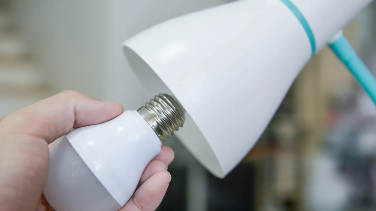 man hand changing the led bulb to white lamp