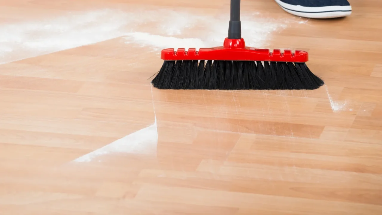 man sweeping hardwood floor