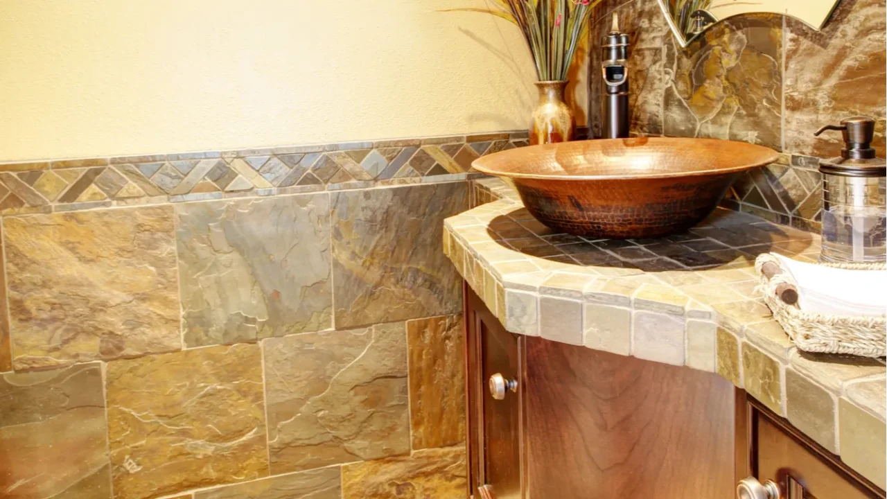 metal sink with wood cabinet and stone tiles