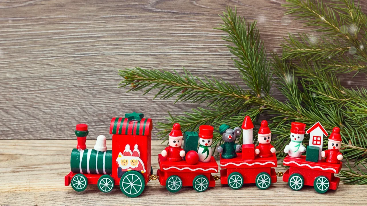 red christmas toy train with fir branches and copy space